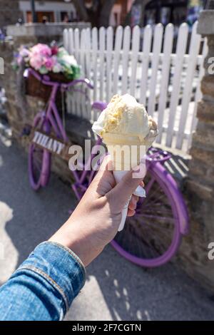 Frau hält Eiskegel mit einem Vintage lila Fahrrad Dekoration in Tihany Ungarn neben dem Plattensee . Stockfoto
