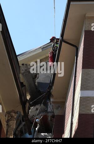 L'Aquila, Italien - 6. April 2009: Die Feuerwehr vor dem Studentenhaus versucht, die in den Trümmern gefangenen Jungen lebendig zu befreien Stockfoto