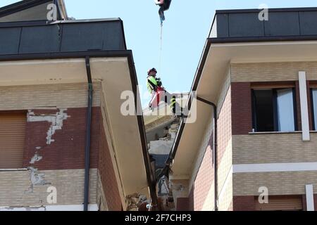 L'Aquila, Italien - 6. April 2009: Die Feuerwehr vor dem Studentenhaus versucht, die in den Trümmern gefangenen Jungen lebendig zu befreien Stockfoto