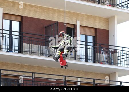 L'Aquila, Italien - 6. April 2009: Die Feuerwehr vor dem Studentenhaus versucht, die in den Trümmern gefangenen Jungen lebendig zu befreien Stockfoto