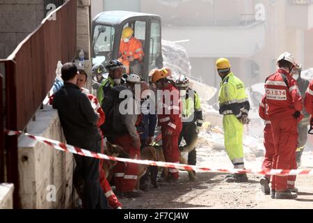 L'Aquila, Italien - 6. April 2009: Retter bei der Arbeit in den Trümmern der Stadt, die durch das Erdbeben zerstört wurden Stockfoto