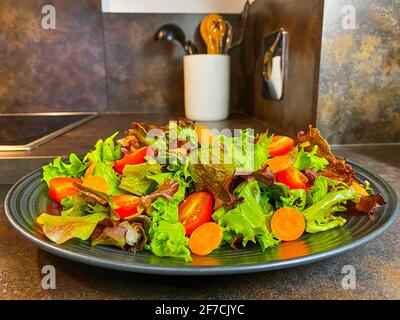 Teller mit frischem Salat aus Salat, Tomaten und Karotten. Stockfoto