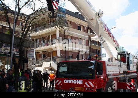 L'Aquila, Italien - 6. April 2009: Die Feuerwehr vor dem Studentenhaus versucht, die in den Trümmern gefangenen Jungen lebendig zu befreien Stockfoto