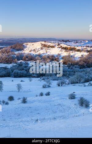 Frühes Winterschnee auf Crickley Hill, von Barrow Wake aus gesehen. Crickley Hill war der Ort von neolithischen Lagerstätten und bronzezeitlichen und eisenzeitlichen Hügelfestungen. Stockfoto