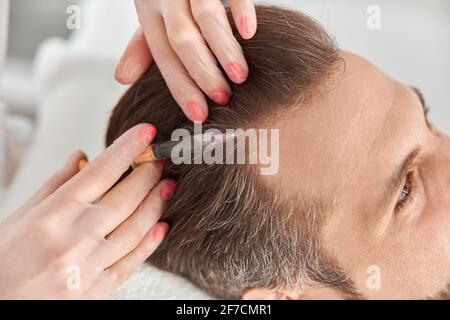 Nahaufnahme macht Mesotherapie-Injektionen an jungen Mann. Behandlung von männlichen durch eine Kosmetikerin zur Straffung und Glättung von Falten auf der Gesichtshaut Stockfoto