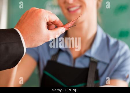 Männlichen Kunden eine Stück Fleisch vom Metzger bei Metzgerei Stockfoto