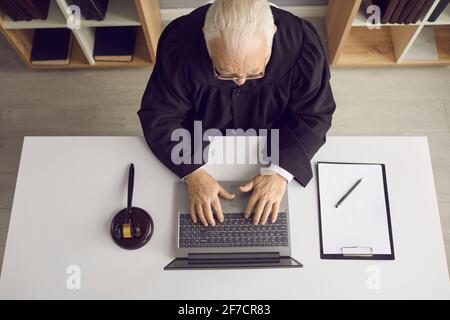 Senior Lawyer sitzt am Schreibtisch mit Laptop und gibt Kunden Rechtsberatung online Stockfoto