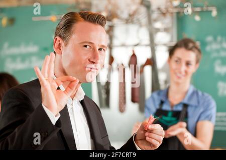 Zufriedener Kunde positive Anzeichen in Butcher shop Stockfoto