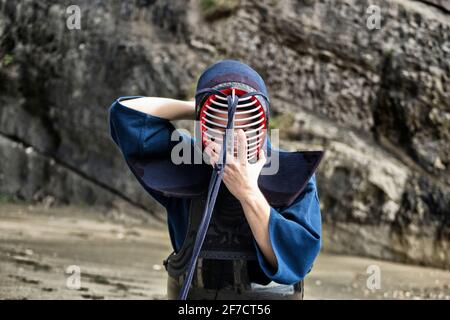 Junger Mann üben Kendo mit Holzschwert. Wort Kendo kann übersetzt werden als "der Weg des Schwertes". Stockfoto