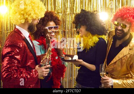 Eine Gruppe von glücklichen Freunden gratuliert der jungen schwarzen Frau bei Retro Geburtstagsparty zum Thema Stockfoto