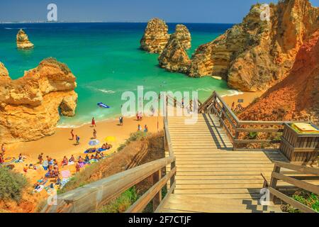 Lagos, Portugal - 21. August 2017: Holztreppe zum malerischen Praia do Camilo mit klarem Wasser. Menschen Sonnenbaden und genießen in beliebt Stockfoto