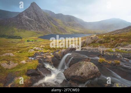 Moody, dramatische Landschaft mit Wasserfall mit Tryfan Gipfel und Llyn Ogwen und Tal im Snowdonia National Park, Nordwales Stockfoto