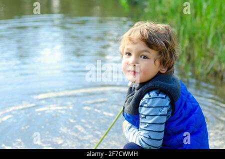 Kleiner Junge, der am See angeln kann Stockfoto