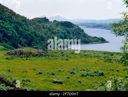 Sehen Sie sich WSW von Kintraw Bronzezeit Alignment, Loch Craignish, Schottland, Großbritannien, von der Aussichtsplattform über Marker Cairn & Standing Stone bis zu Paps of Jura an. Stockfoto