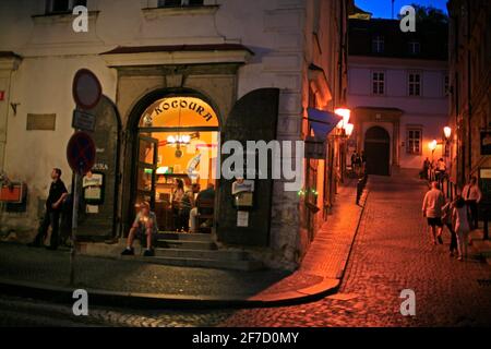 Eingang und Treppe zum Restaurant U Kocoura (Katze) auf dem Malostranske Namesti Platz in der Abenddämmerung. Prager Mala Strana Stockfoto