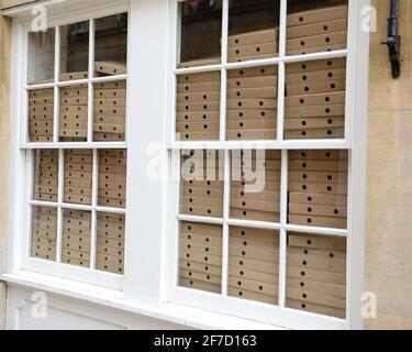 cambridge, Vereinigtes Königreich, England, 03-04-2021. Stapel von aufgemachten braunen Pizzakästen im Fenster der Pizzeria Stockfoto