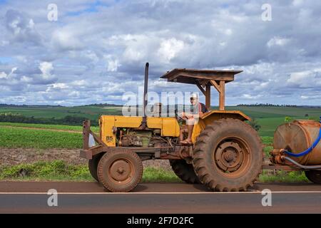Paraguayischer Landwirt, der den alten Traktor Valmet 85 ID aus den 1970er Jahren auf der Straße durch Felder auf dem Land in der Nähe der Stadt Edelira im ländlichen Itapúa, Paraguay, fährt Stockfoto
