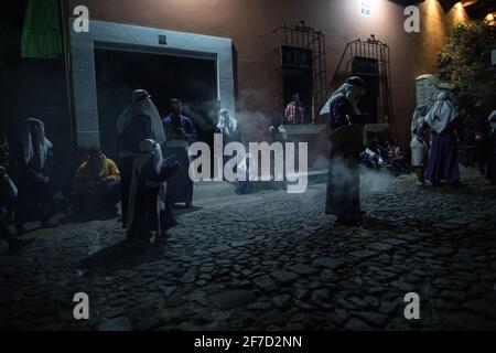 Weihrauch füllt die Straßen nachts, während die Menschen an einer Semana Santa Prozession während der Karwoche in Antigua, Guatemala, teilnehmen. Stockfoto