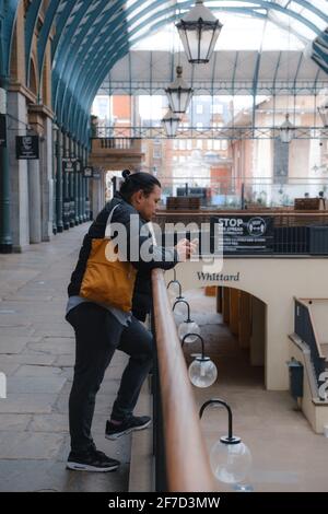 London, Großbritannien - April 2021 : EINE Person steht während der dritten nationalen Sperre auf dem Covent Garden Market Stockfoto