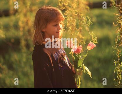 Junges Mädchen pflücken Wildblumen in Garten, Winkfield, Britannien, England Stockfoto