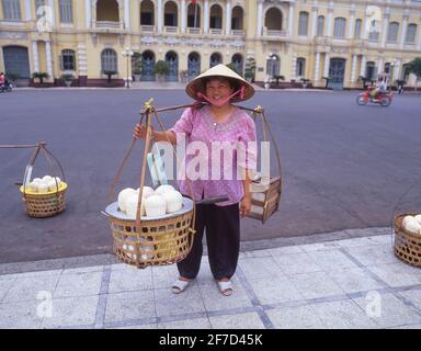 Frau, die Kokosnusssaft verkauft, vor dem Rathaus von Ho Chi Minh, Union Square, Ho Chi Minh City (Saigon), Sozialistische Republik Vietnam Stockfoto