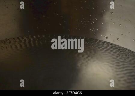 Tibetische Klangschale voller Wasser, Nahaufnahme von Wassertropfen, Klangheilungsinstrument Stockfoto