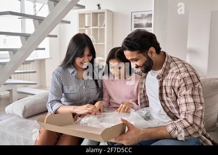 Aufgeregt indische Familie mit teen Tochter Auspacken Paket zu Hause. Stockfoto