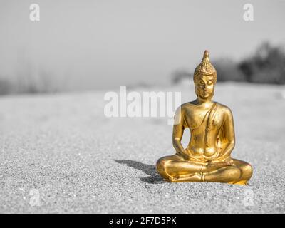 Kleine goldene buddha-Statue oder Buddharupa im Sand Stockfoto