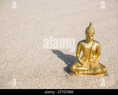 Kleine goldene buddha-Statue oder Buddharupa im Sand Stockfoto