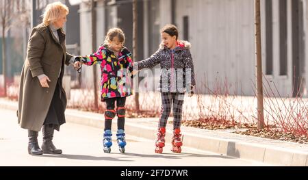 Großmutter lehrt Enkelin Rollschuh Stockfoto