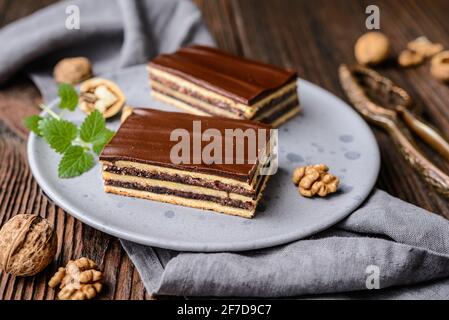 Köstlicher Kakao- und Walnusskuchen mit Pflaumenmarmelade, gekrönt mit Schokoladenfrosting Stockfoto