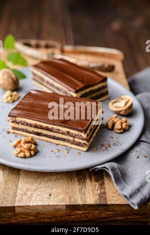 Köstlicher Kakao- und Walnusskuchen mit Pflaumenmarmelade, gekrönt mit Schokoladenfrosting Stockfoto