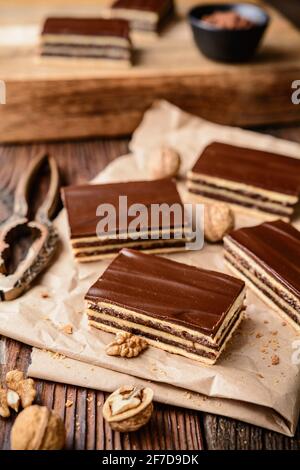 Köstlicher Kakao- und Walnusskuchen mit Pflaumenmarmelade, gekrönt mit Schokoladenfrosting Stockfoto