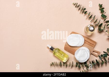 Flaschen von Essenz oder Serum mit natürlichen Eukalyptusblättern auf beigem Hintergrund. Naturkosmetik und Spa Flat Lay Stockfoto