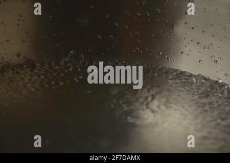 Tibetische Klangschale voller Wasser, Nahaufnahme von Wassertropfen, Klangheilungsinstrument Stockfoto