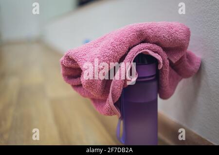 Blaues Handtuch und blauer Shaker auf einem Tisch im Fitnessraum Stockfoto