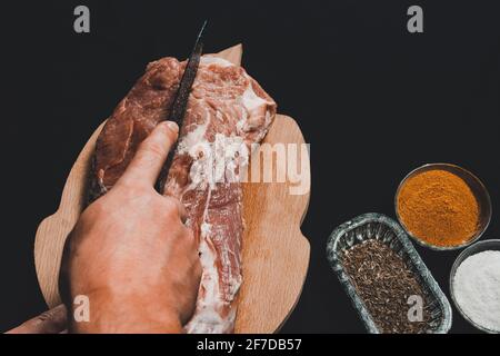 Der Metzger schneidet das Schweinefleisch, mariniert das rohe Fleisch und kocht den Kebab.2020 Stockfoto