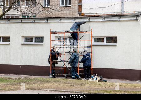 WEISSRUSSLAND, NOWOPOLOTSK - 29. APRIL 2020: Arbeiter malen eine Gebäudewand Stockfoto