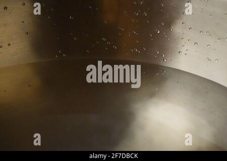 Tibetische Klangschale voller Wasser, Nahaufnahme von Wassertropfen, Klangheilungsinstrument Stockfoto