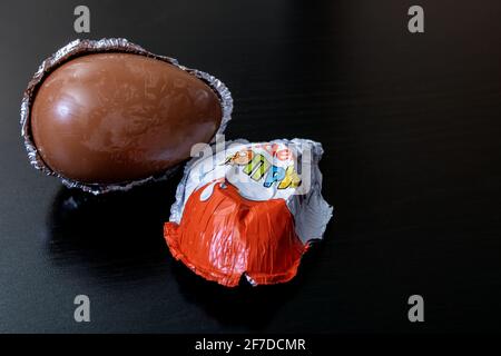 WEISSRUSSLAND, MINSK - 22. JUNI 2020: Kinder überraschen Schokoladenei auf schwarzem Hintergrund Stockfoto