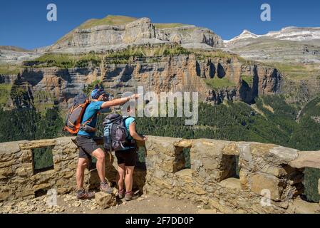 Wanderer, die vom Aussichtspunkt Mirador de Calcilarruego aus das Ordesa-Tal betrachten (Nationalpark Ordesa y Monte Perdido, Aragon, Spanien, Pyrenäen) Stockfoto