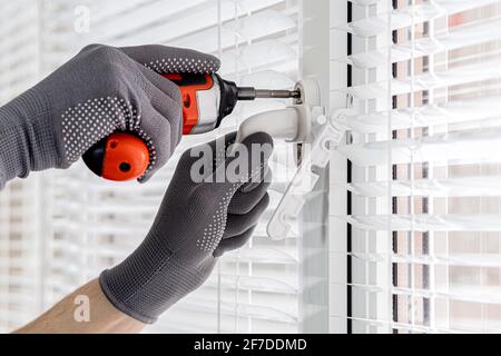 Einstellen des Begrenzers für die Fensterflügel-Position. Schutz vor Zugluft Stockfoto