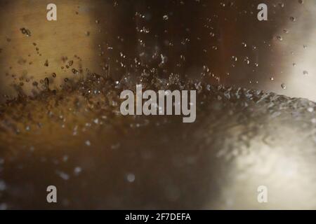 Tibetische Klangschale voller Wasser, Nahaufnahme von Wassertropfen, Klangheilungsinstrument Stockfoto