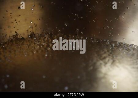 Tibetische Klangschale voller Wasser, Nahaufnahme von Wassertropfen, Klangheilungsinstrument Stockfoto