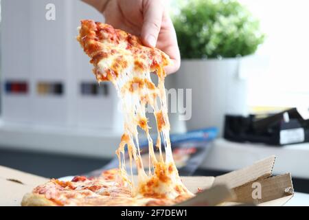 Hand nimmt ein Stück köstliche heiße Pizza Nahaufnahme Stockfoto