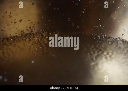 Tibetische Klangschale voller Wasser, Nahaufnahme von Wassertropfen, Klangheilungsinstrument Stockfoto