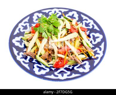 Köstlicher Kalbsalat mit Gurken und Avocado auf authentischem orientalischen Teller. Isoliert auf weißem Hintergrund. Stockfoto