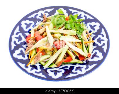 Köstlicher Kalbsalat mit Gurken und Avocado auf authentischem orientalischen Teller. Isoliert auf weißem Hintergrund. Stockfoto