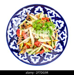 Köstlicher Kalbsalat mit Gurken und Avocado auf authentischem orientalischen Teller. Isoliert auf weißem Hintergrund. Stockfoto