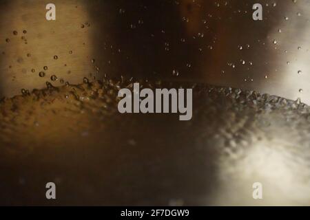 Tibetische Klangschale voller Wasser, Nahaufnahme von Wassertropfen, Klangheilungsinstrument Stockfoto